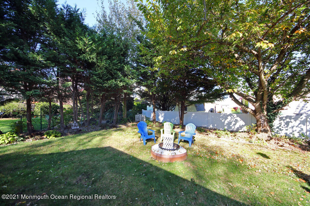 1132 Mohegan Road Manasquan, NJ 08736 - Photo 6 of 35 a view of a backyard with table and chairs under an umbrella