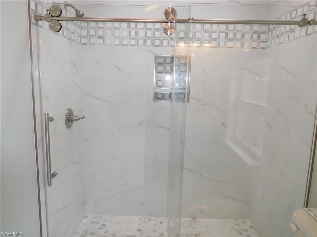 255 Jones Road Winston-Salem, NC 27107 - Photo 13 of 26 Master Bathroom has large walk-in tiled shower, double sink vanity w/quartz top and tile floor. Very bright bathroom w/large window.