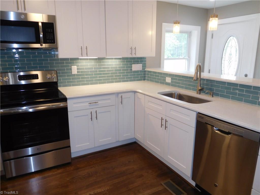 255 Jones Road Winston-Salem, NC 27107 - Photo 8 of 26 White shaker style cabinets, quartz counters, tile backsplash & under cabinet lights. New Stainless Steel appliance package: built-in MW, DW, range/oven & fridge.