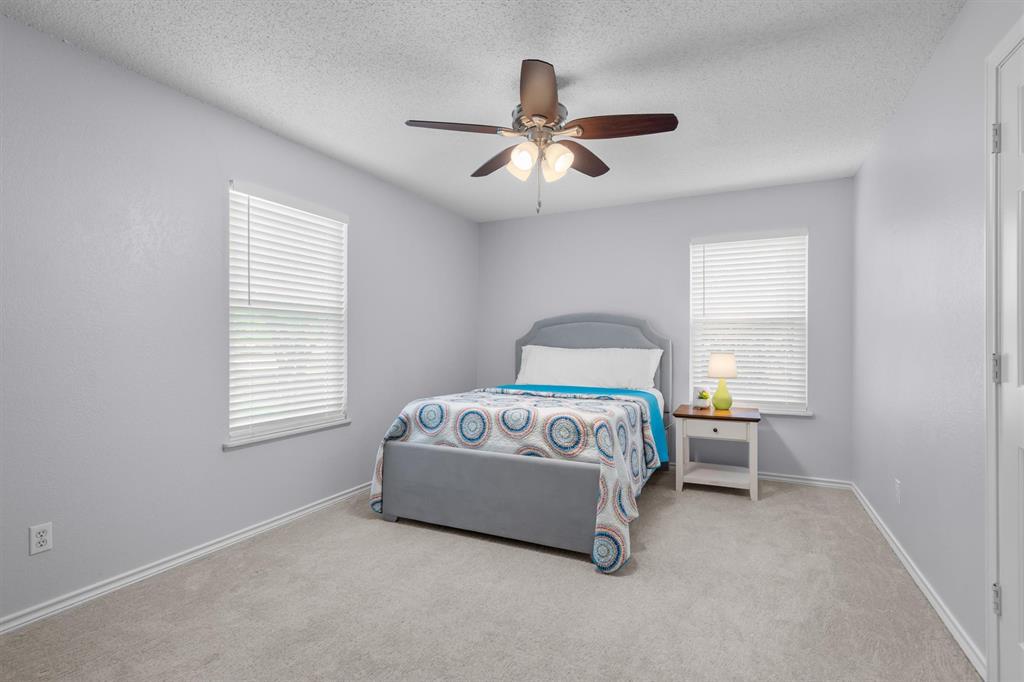 410 Simmons Road Double Oak, TX 75077 - Photo 30 of 40 Comfortable secondary bedroom with ceiling fan and ample closet space.