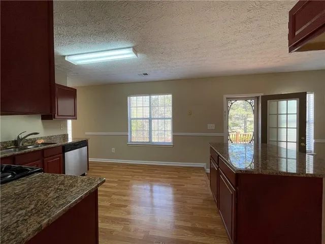a kitchen with granite countertop a stove and a sink