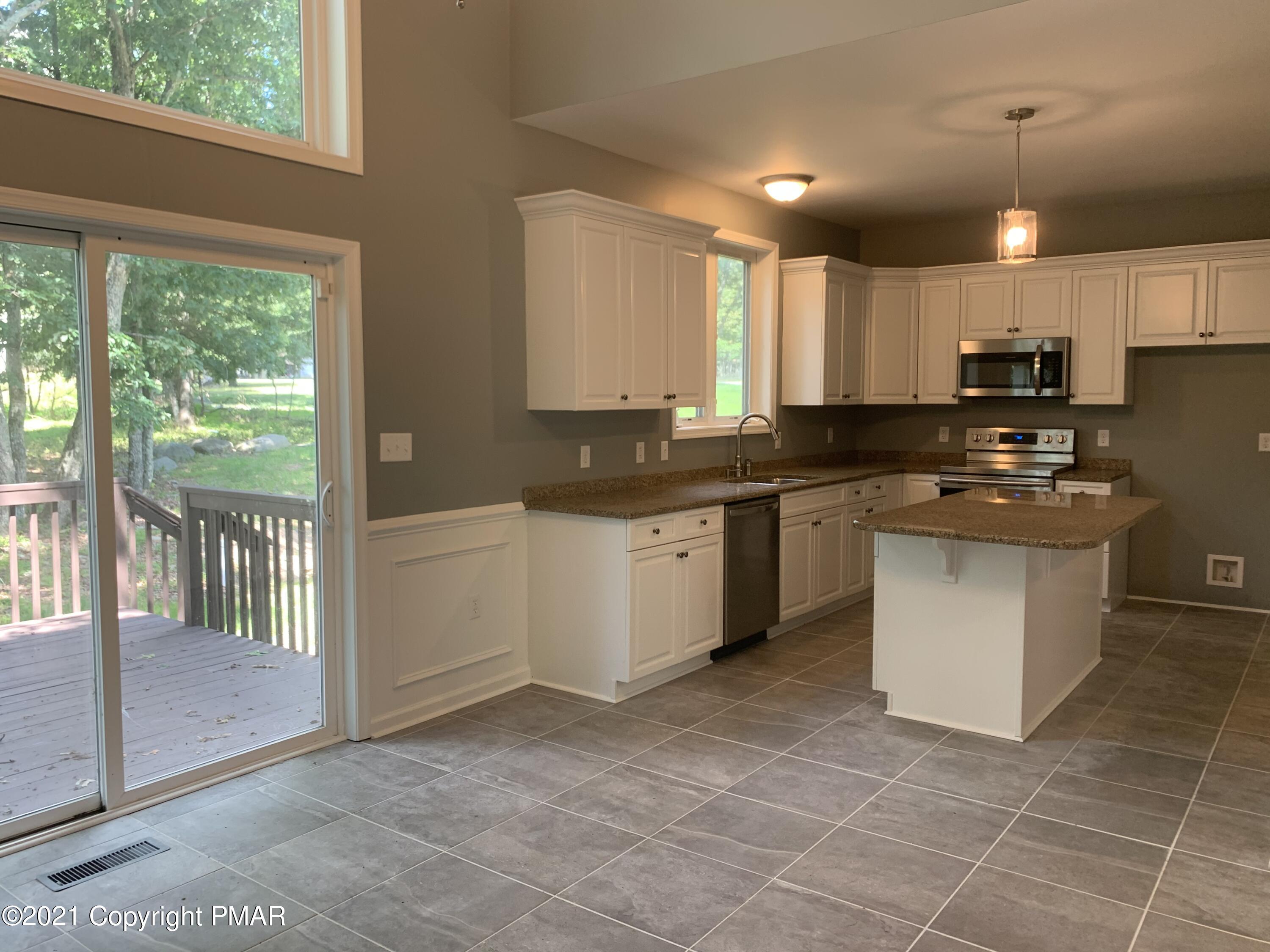 136 Pike Road Bushkill, PA 18324 - Photo 12 of 35 a kitchen with stainless steel appliances granite countertop a stove a sink and a refrigerator