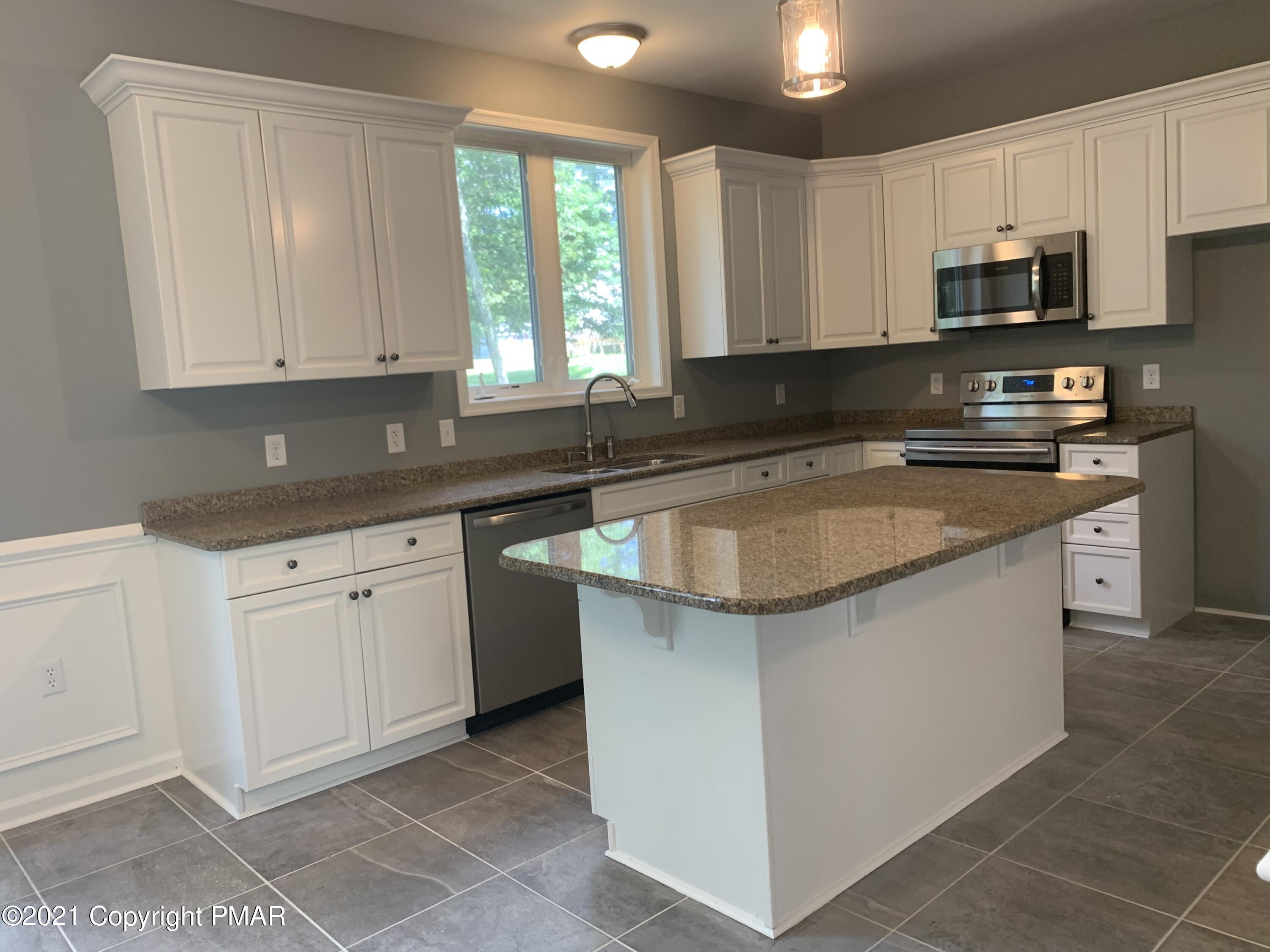 136 Pike Road Bushkill, PA 18324 - Photo 13 of 35 a kitchen with stainless steel appliances granite countertop a sink stove and microwave
