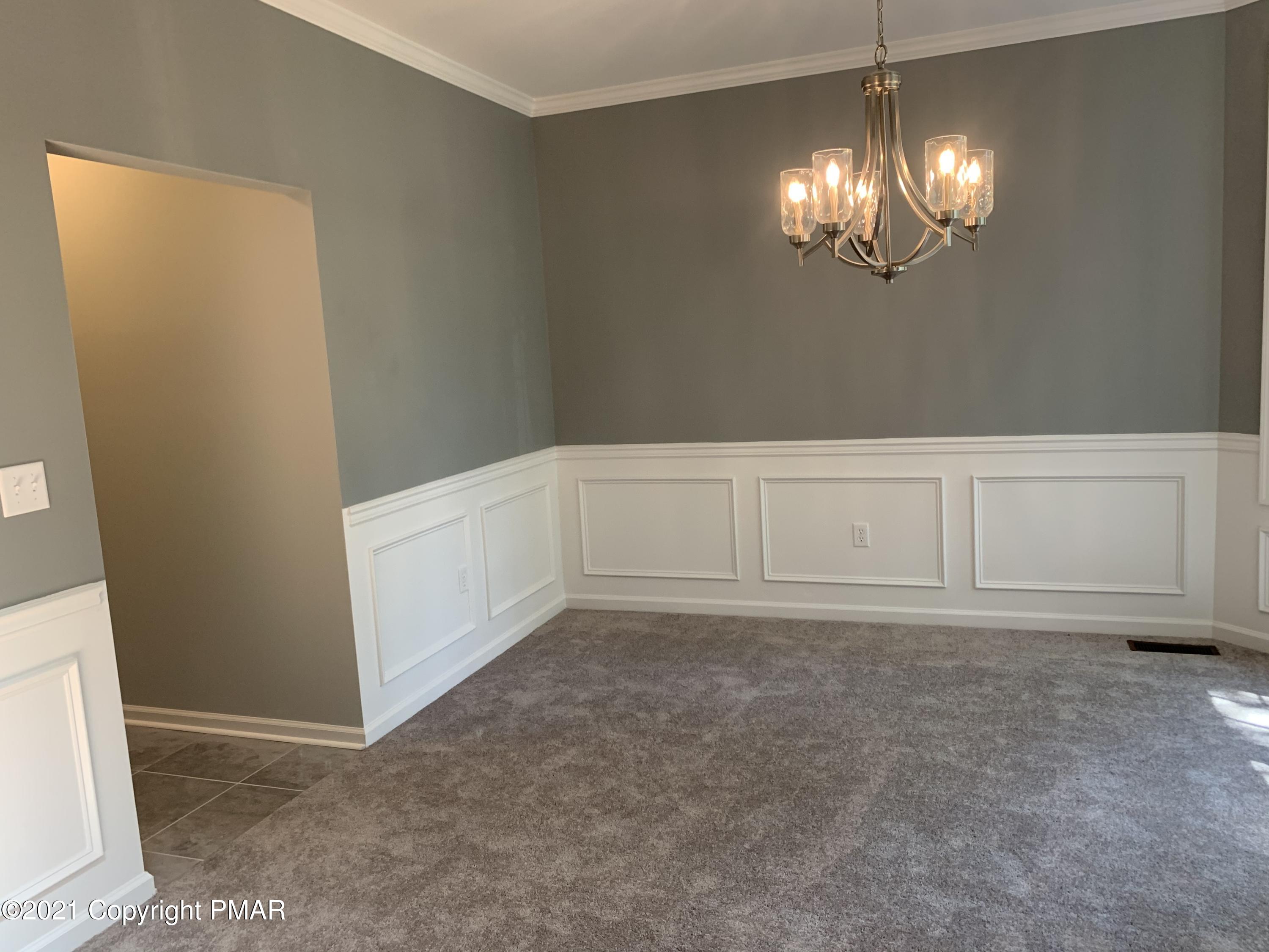 136 Pike Road Bushkill, PA 18324 - Photo 4 of 35 a view of an empty room with chandelier fan and refrigerator