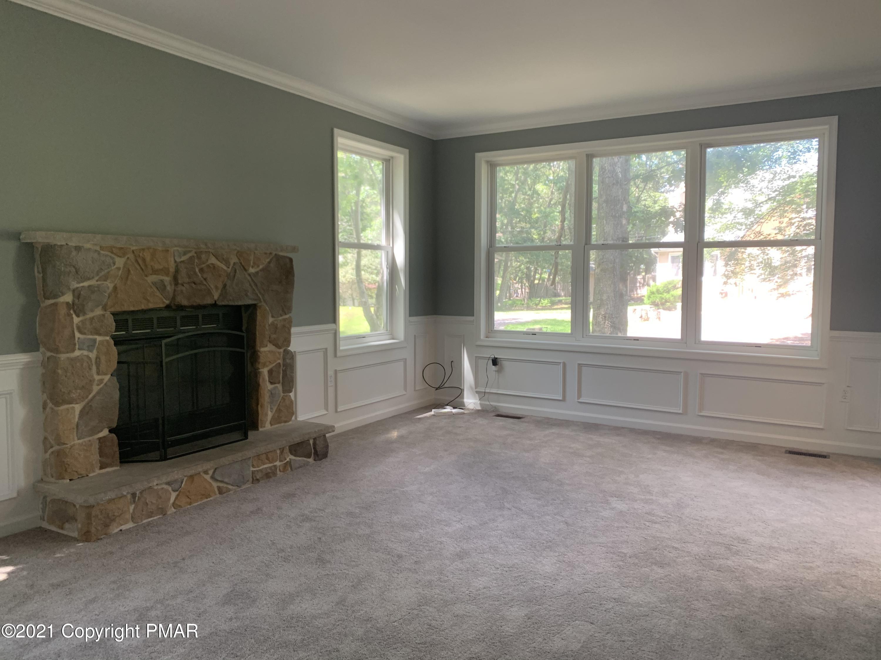 136 Pike Road Bushkill, PA 18324 - Photo 9 of 35 an empty room with a fireplace and windows