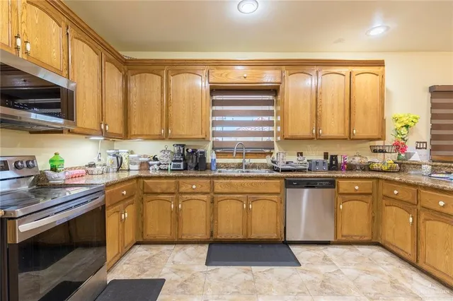a kitchen with stainless steel appliances granite countertop a stove sink and cabinets