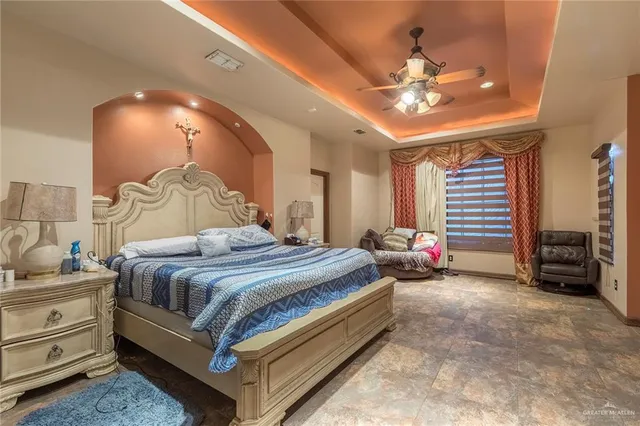 a spacious bedroom with a bed and a chandelier