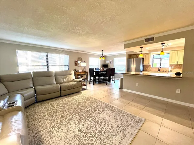 a living room with furniture and a dining table with kitchen view