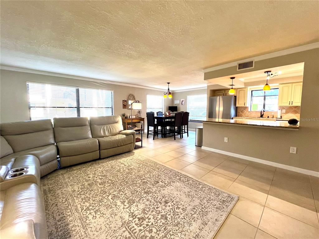 2101 Hammock Pine Boulevard, Unit 2101 Clearwater, FL 33761 - Photo 4 of 24 a living room with furniture and a dining table with kitchen view