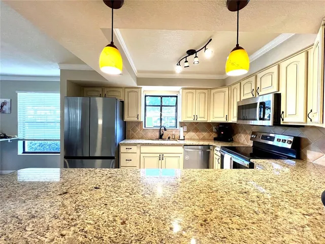 a kitchen with stainless steel appliances granite countertop a stove a sink and a refrigerator