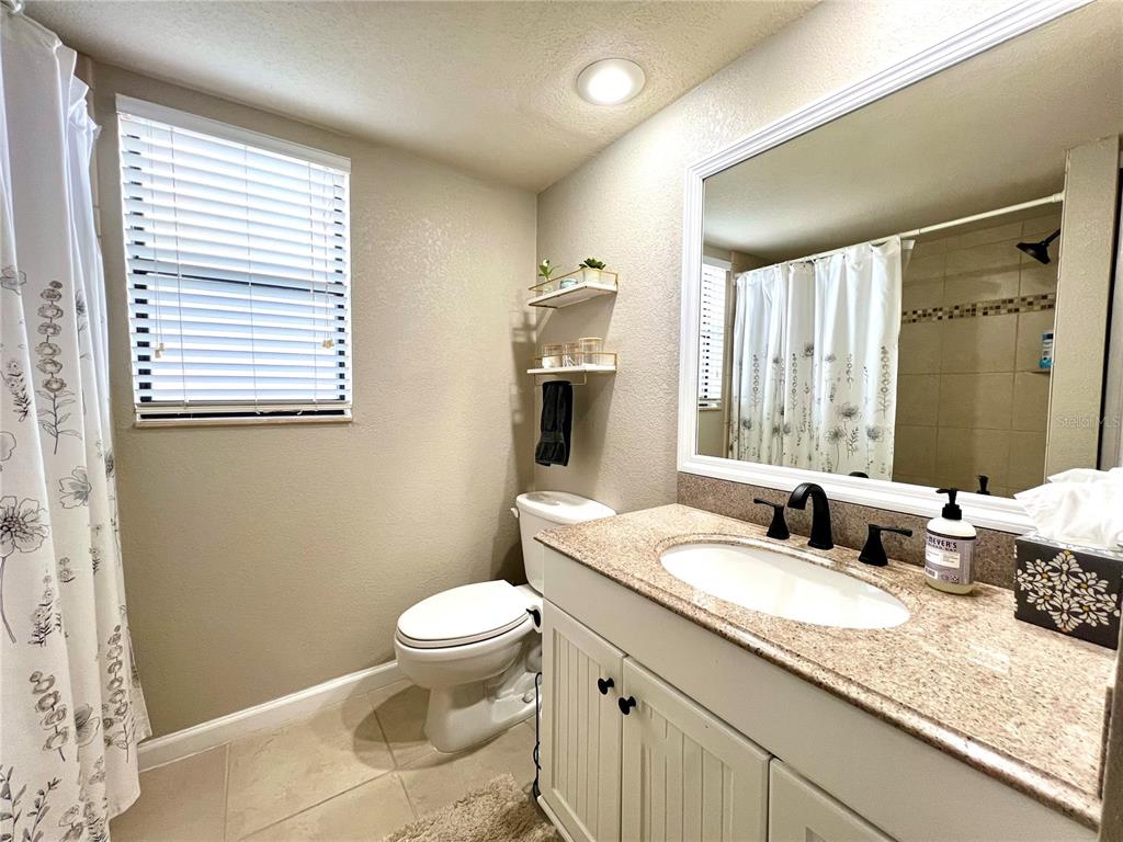 2101 Hammock Pine Boulevard, Unit 2101 Clearwater, FL 33761 - Photo 8 of 24 a bathroom with a granite countertop sink toilet and shower