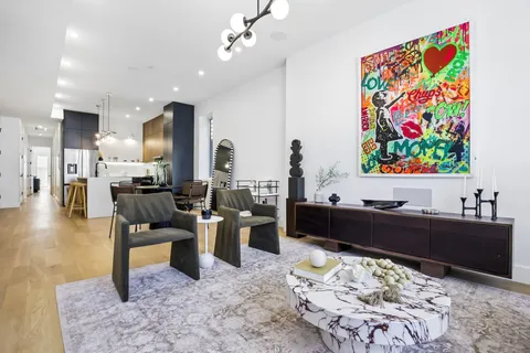 a living room with furniture and painting on the wall