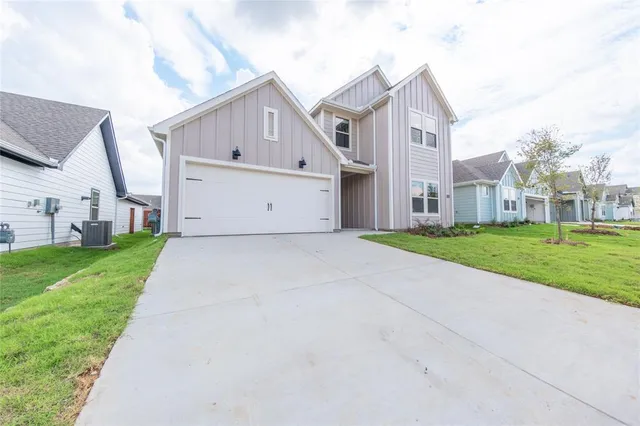 a view of a white house with a big yard and large tree