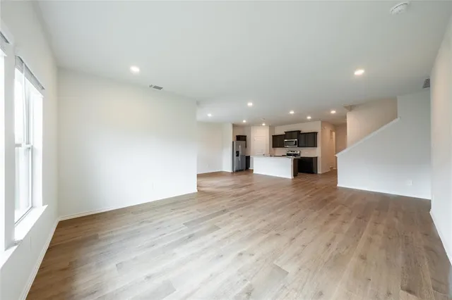 a view of kitchen with kitchen island a sink wooden floor and a window