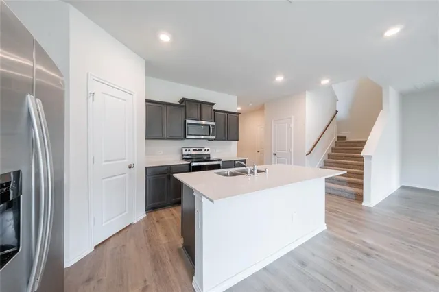 a kitchen with appliances a sink and a refrigerator