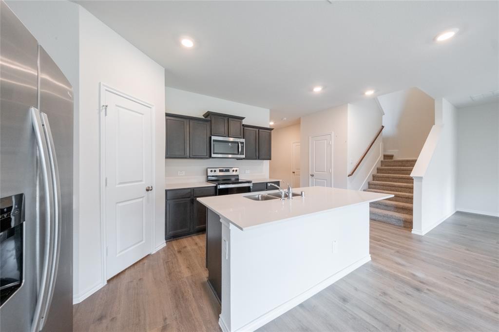 13156 Dawson Drive Providence Village, TX 76227 - Photo 9 of 31 a kitchen with appliances a sink and a refrigerator