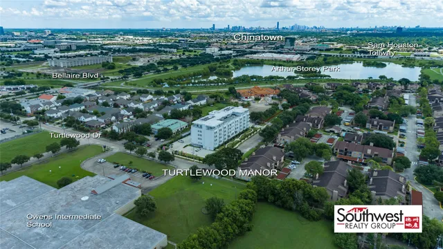 an aerial view of residential houses with outdoor space and trees
