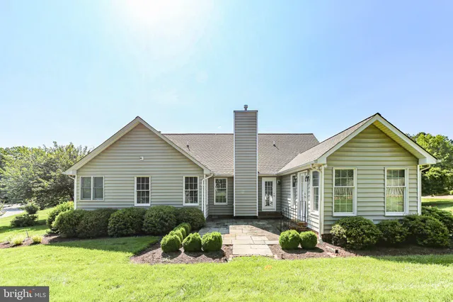 a view of a house with a yard and potted plants