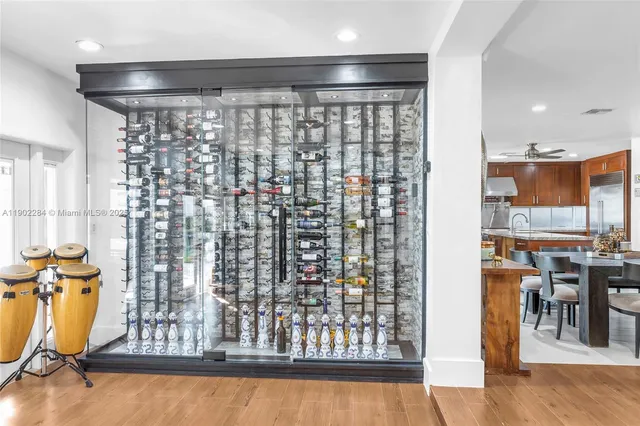 a open kitchen with stainless steel appliances granite countertop a stove top oven a sink dishwasher a dining table and chairs with wooden floor