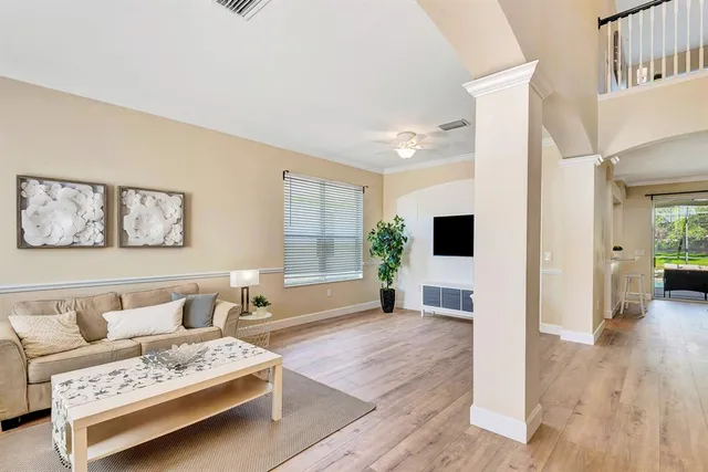 a living room with furniture a flat screen tv and a potted plant