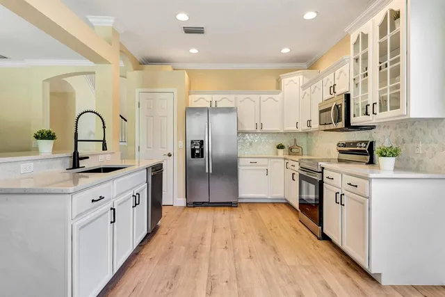 a kitchen with stainless steel appliances a refrigerator sink and microwave