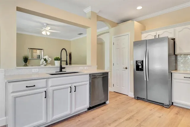 a view of kitchen with stainless steel appliances kitchen island and living room