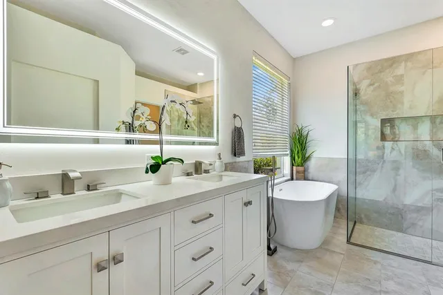 a bathroom with a tub a sink and a window