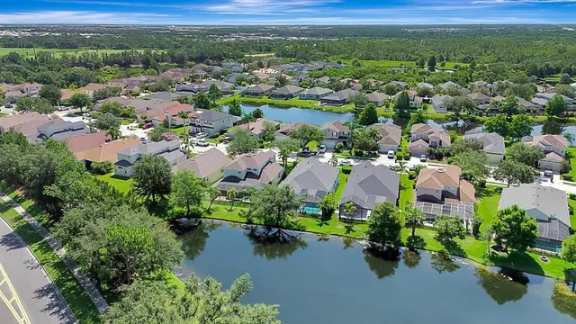 an aerial view of a houses with a yard and lake view