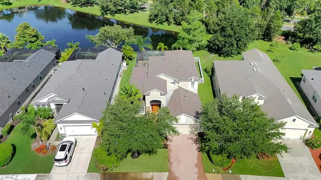 an aerial view of a house with a garden and lake view