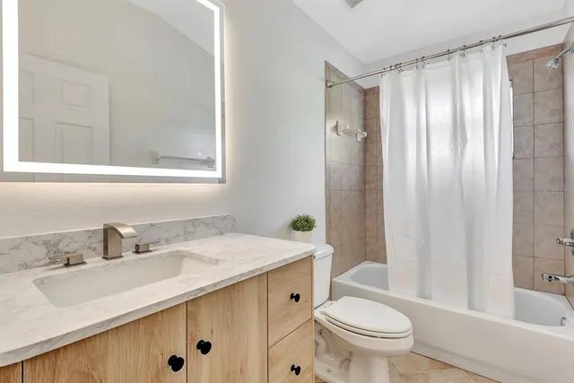 a view of a house with a small yard and wooden fence