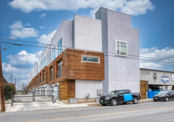a view of a building and car parked on the road