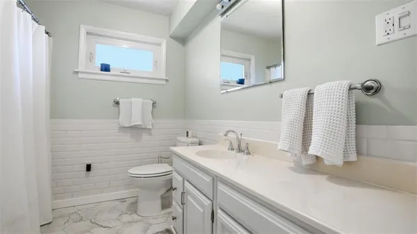 a bathroom with a sink a toilet and a mirror