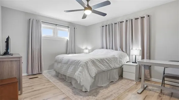 a bedroom with a bed table and a window