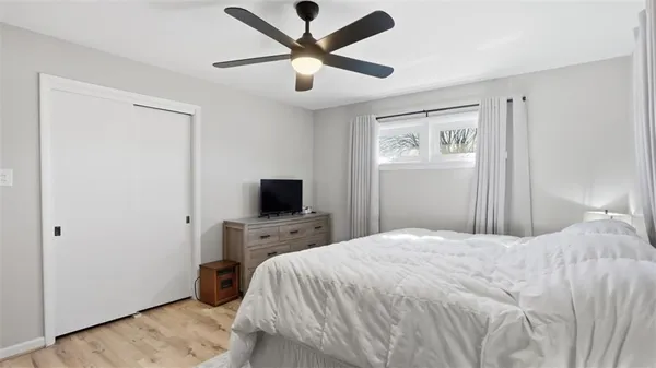 a bedroom with a bed and a flat tv screen on dresser
