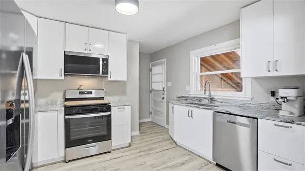 a kitchen with a sink stove and microwave