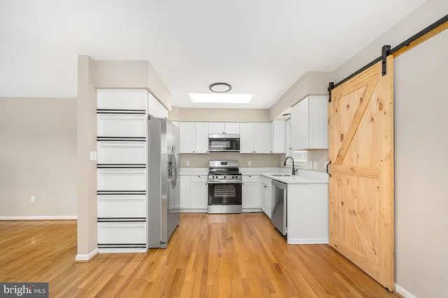 a kitchen with a refrigerator and white cabinets