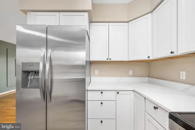 a kitchen with cabinets and a refrigerator