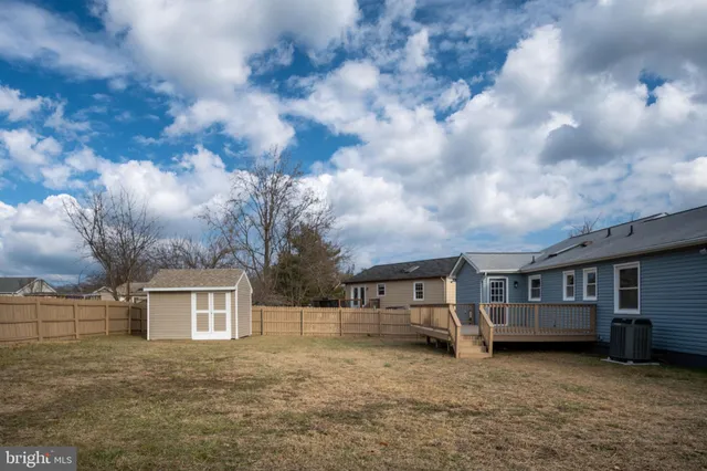 a front view of a house with a garden and trees