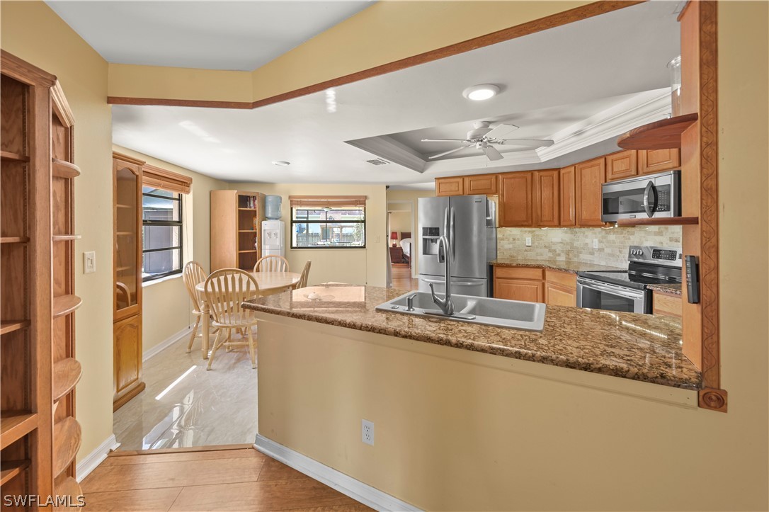 17413 Butler Road Fort Myers, FL 33967 - Photo 21 of 33 a large kitchen with kitchen island a large counter top space a sink and appliances