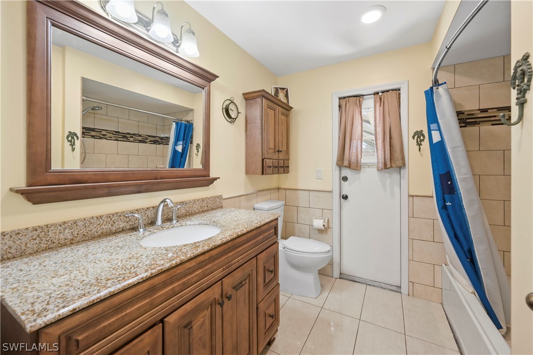 17413 Butler Road Fort Myers, FL 33967 - Photo 5 of 33 a bathroom with a granite countertop sink a mirror and a toilet
