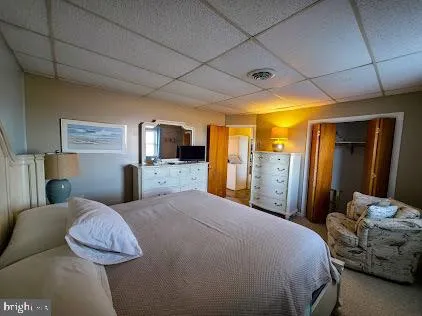 a bedroom with a large bed and a flat tv screen