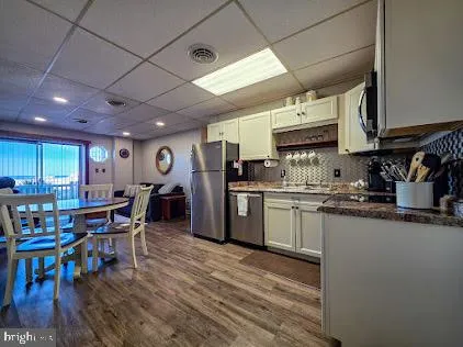 a kitchen with stainless steel appliances granite countertop a refrigerator a stove a sink and a microwave