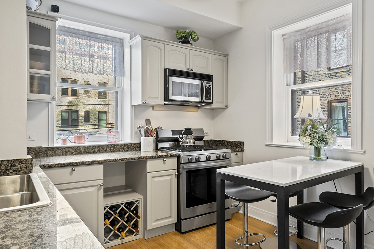 670 West Irving Park Road, Unit G6 Chicago, IL 60613 - Photo 23 of 38 a kitchen with stainless steel appliances a stove a sink and a refrigerator