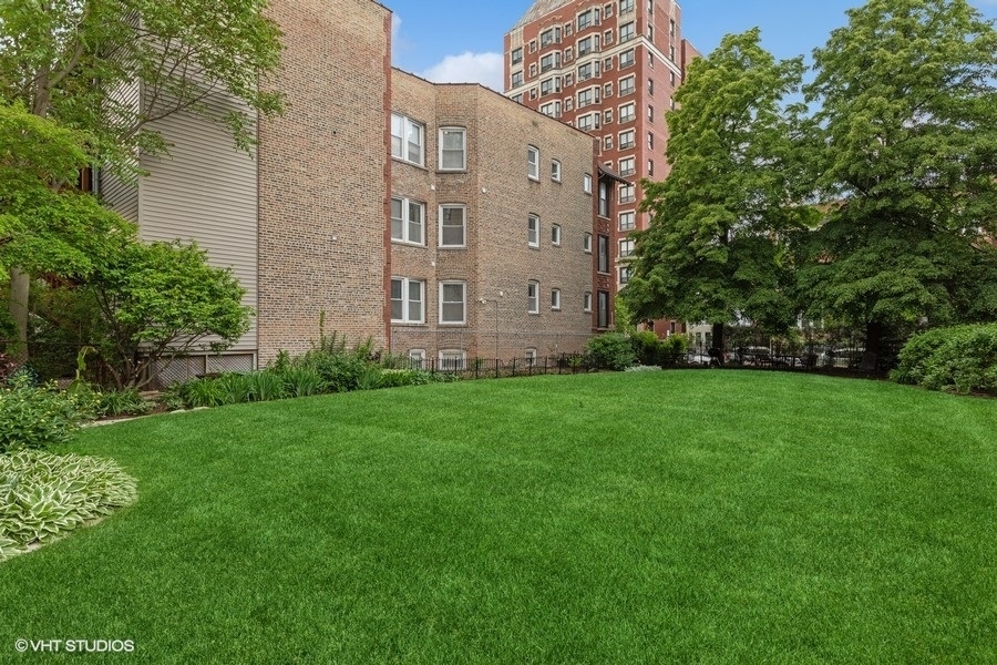 670 West Irving Park Road, Unit G6 Chicago, IL 60613 - Photo 35 of 38 a view of a building next to a big yard and large trees