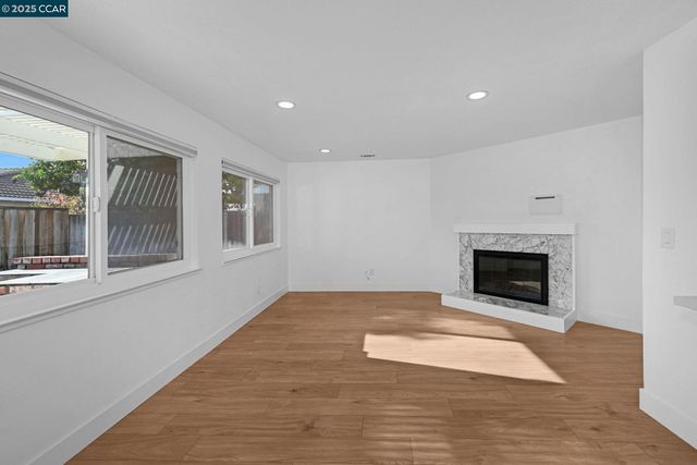 a view of an empty room with a fireplace and a window