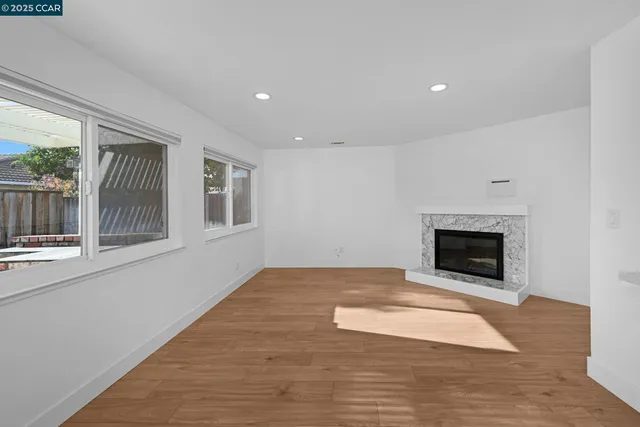 a view of an empty room with a fireplace and a window