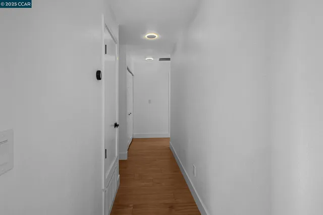 a view of a hallway with wooden floor