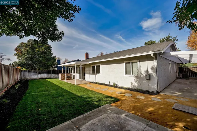 a front view of house with yard and trees around