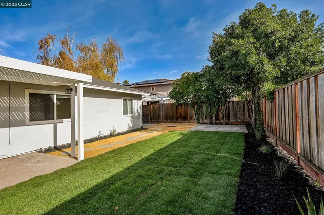 a view of a house with backyard and sitting area