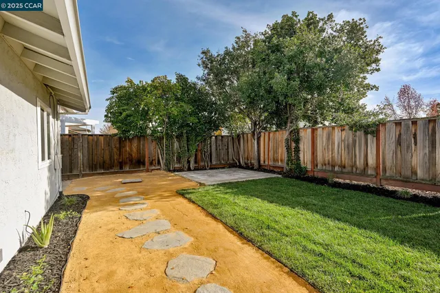 a view of a backyard with wooden fence